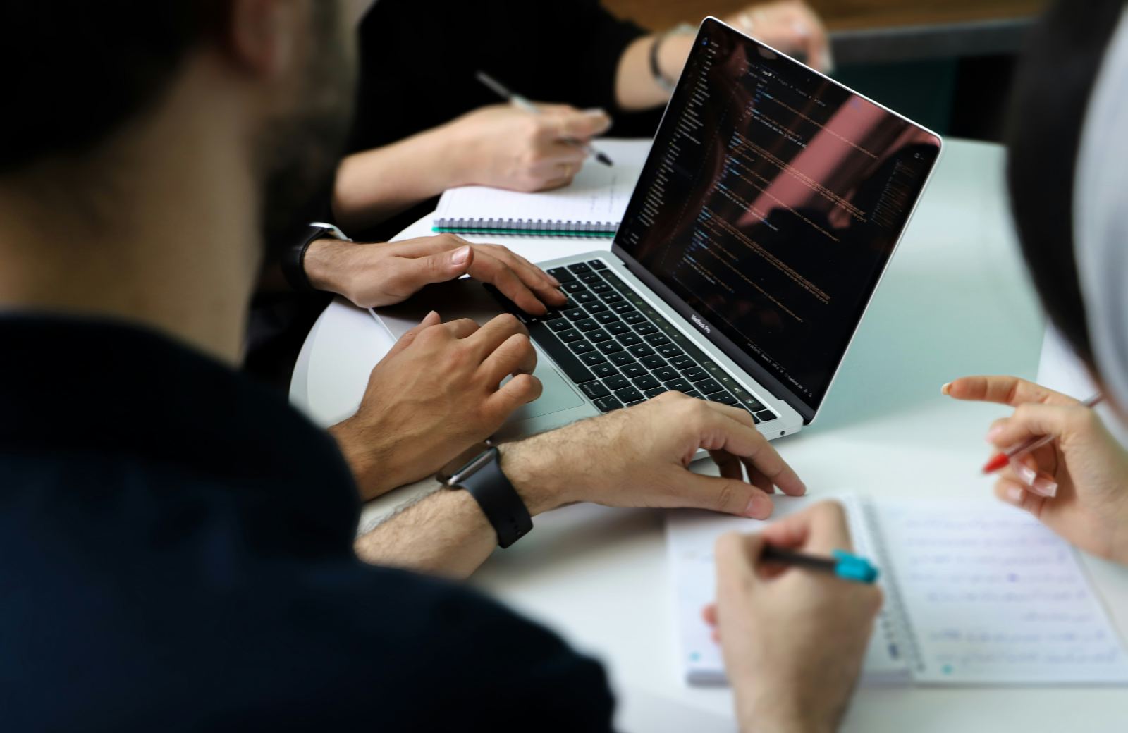 Audit working session: laptop with code, notes and hands at a table